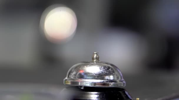 Silver counter bell on a dark surface with blurry background — Stock Video