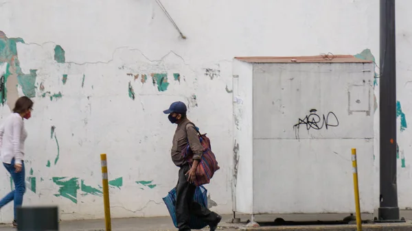 Meksika 'dan gelen bir sokakta yürüyen maskeli insanlar.