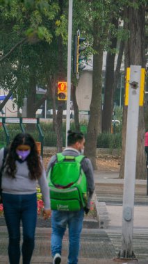 Meksika 'dan gelen bir sokakta yürüyen maskeli insanlar.