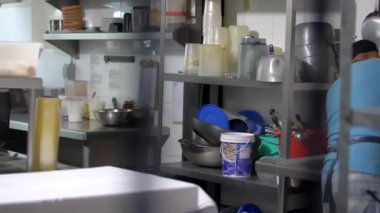 Restoranın mutfağında bulaşık yıkayan mavi gömlekli İspanyol adam.