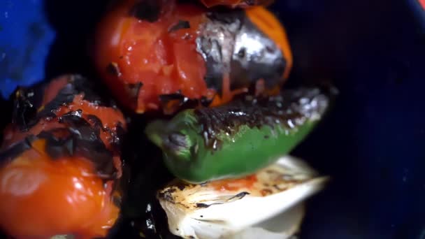 Запечений перець чилі, помідори та цибуля в синій тарілці — стокове відео