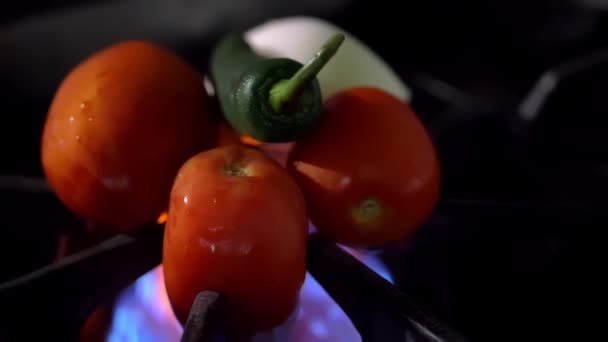 Жареный перец чили, помидоры и лук на открытой горелке — стоковое видео