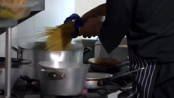 Chefs hispanos cocinando pasta en una cocina de restaurante — Vídeos de Stock