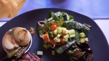 Izgara et, salata, kızarmış soğan ve tabakta kırmızı biber.