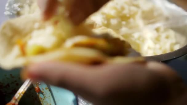 Hände fügen Kartoffelpüree zu einem Taco mit weicher Tortilla hinzu — Stockvideo