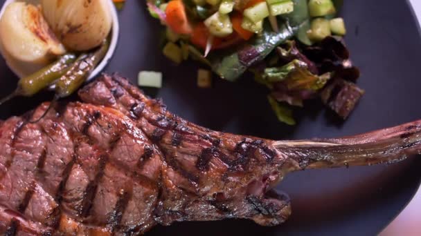 Grilled meat, salad, and roasted onions and chili peppers on plate — Stock Video