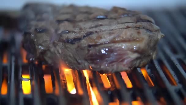 Sepotong daging yang tampak juicy atas api panggangan — Stok Video