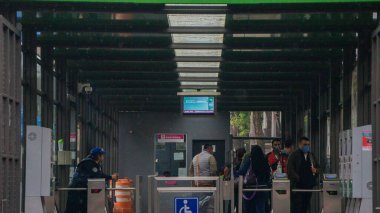 Mexico City metro istasyonuna giren maskeli insanlar.