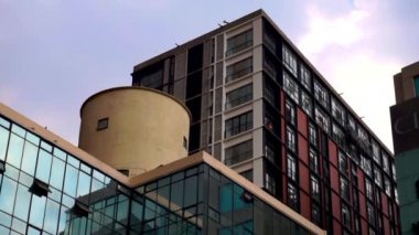 Mexico City 'den modern binaların üzerinde hafif bulutlu bir gökyüzü var.
