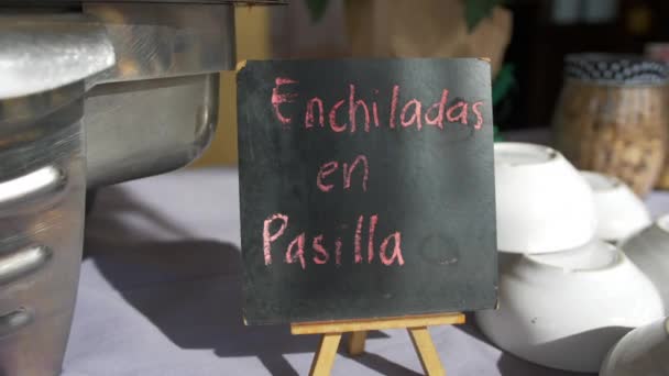 金属罐和黑色标志，桌子上有粉红色的西班牙文字 — 图库视频影像