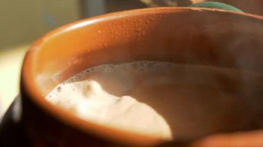 Kil bir tencerede sert güneş ışığıyla kakao kaynıyor.