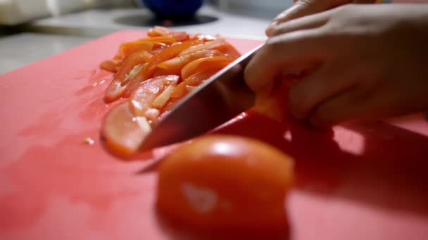 Mãos de cozinheiro feminino lentamente cortando um tomate — Vídeo de Stock