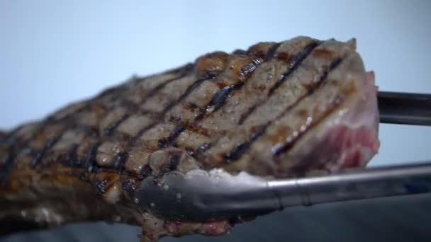 Šťavnatý kus masa na grilu s rozmazaným pozadím — Stock video