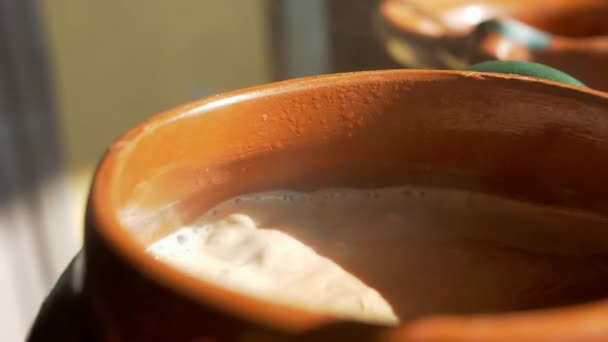 Boiling cocoa in a clay pot with hard sunlight — Stock Video