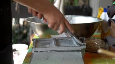 Tortilla yapmak için mısır hamurunu düzleştiren eller.