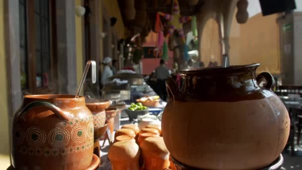 Pots d'argile et plats sur une longue table blanche au restaurant mexicain — Video