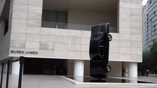 Schwarzer Oldtimer steht senkrecht vor dem Jumex Museum — Stockvideo