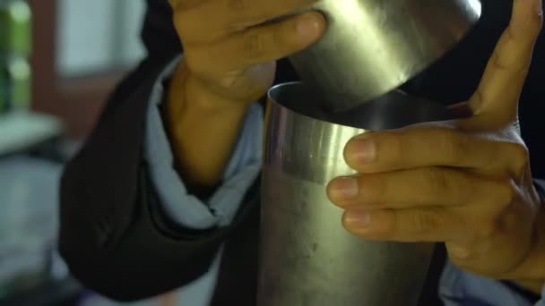 Латиноамериканец-бармен трясет коктейль-шейкер с размытым фоном — стоковое видео