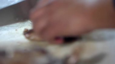 Bir parça eti yavaşça dilimleyen elleri pişir.