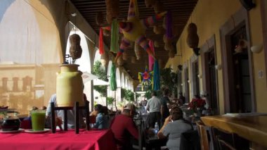 Restorandaki masalarda oturan insanlar tavandan sallanan pinatalarla.