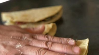 Kadın aşçı Quesadillas 'ı büyük bir Comal' a yerleştiriyor.