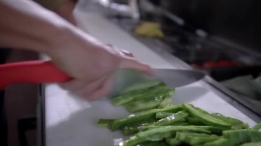 Beyaz kesme tahtasındaki yumruları yavaş yavaş dilimleyen elleri pişir