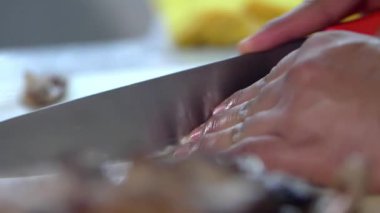 Bir parça eti yavaşça dilimleyen elleri pişir.