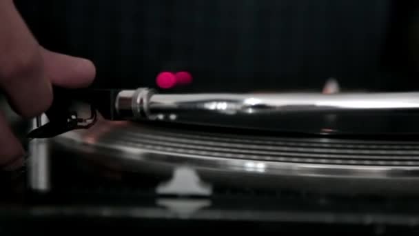 Ręczne trzymanie igły gramofonu z obrotową płytą winylową za nią — Wideo stockowe