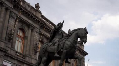 Bulutlu gökyüzünün altında ata binen bir adamın düşük açılı görüntüsü.