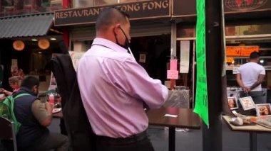 Çin Mahallesi 'nde maskeli iki adam enstrüman çalıyor.