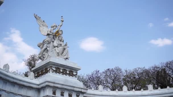 Мраморные статуи ангелов и бывшего президента Мексики под голубым небом — стоковое видео