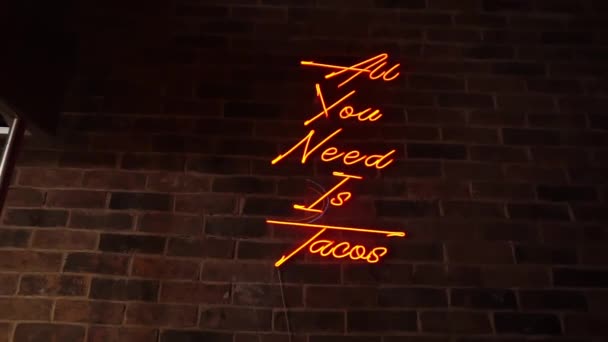 Funny orange neon light on red brick wall — Stock Video