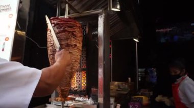 Erkek eller restoranın önünde geleneksel bir Meksikalı papazın bavulunu kesiyor.