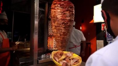 Adam sokakta geleneksel bir Meksikalı papazın bavulunu kesiyor.