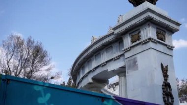 Arka planda mavi gökyüzü ve ağaçlar olan mermer sütunlar.