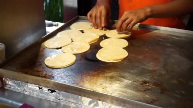 Erkek eller mangalda tortilla çeviriyor.