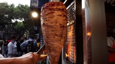 Adam sokakta geleneksel bir Meksikalı papazın bavulunu kesiyor.