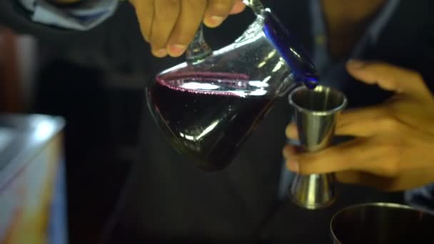 カクテルシェーカーに赤い飲み物を注ぐバーテンダーの手 — ストック動画
