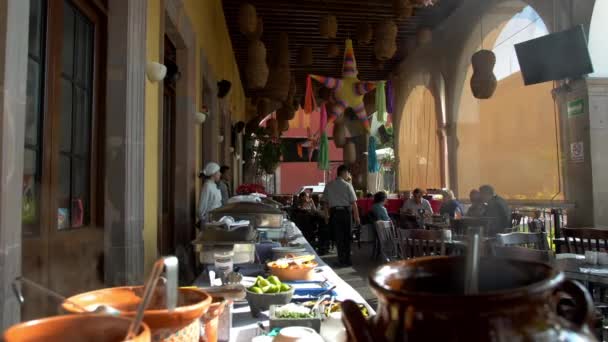 Macetas de arcilla y platos en mesa blanca larga en restaurante mexicano — Vídeo de stock