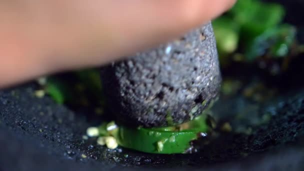 Close-up de mão moagem pimentas em um molcajete mexicano — Vídeo de Stock