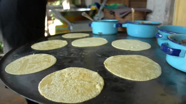 Female cook placing handmade tortillas on a big comal Stock Video Footage  by ©KanelBulle #456050806