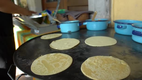 Žena kuchařka umístění ručně vyrobené tortilly na velký komal — Stock video