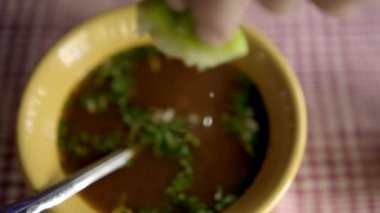 Beyaz ve kırmızı kareli masa örtüsü üzerinde bir kase Meksika sığır eti güveci.