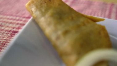 Meksika sepeti tacoları ve beyaz tabakta soğan dilimleri.