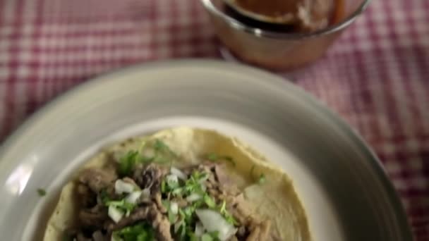 Rundvlees barbacoa taco en glas kopje hete saus op een tafel — Stockvideo