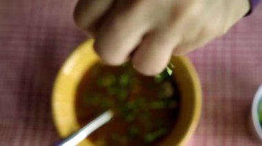 Beyaz ve kırmızı kareli masa örtüsü üzerinde bir kase Meksika sığır eti güveci.