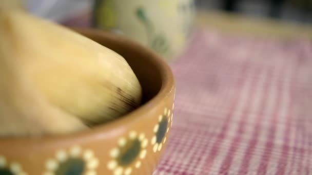 Tamale in clay bowl above a white and red checkered tablecloth — Stock Video