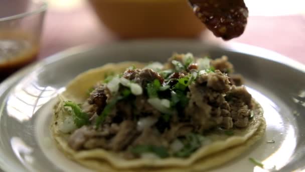 Přidání červené pálivé omáčky do hovězího barbacoa taco — Stock video