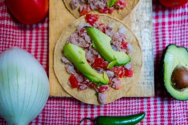 Kareli masa örtüsünün üstünde Meksika ton balığı ve sebze.