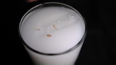 Bir bardak siyah arka planlı geleneksel Meksika horchata suyu.